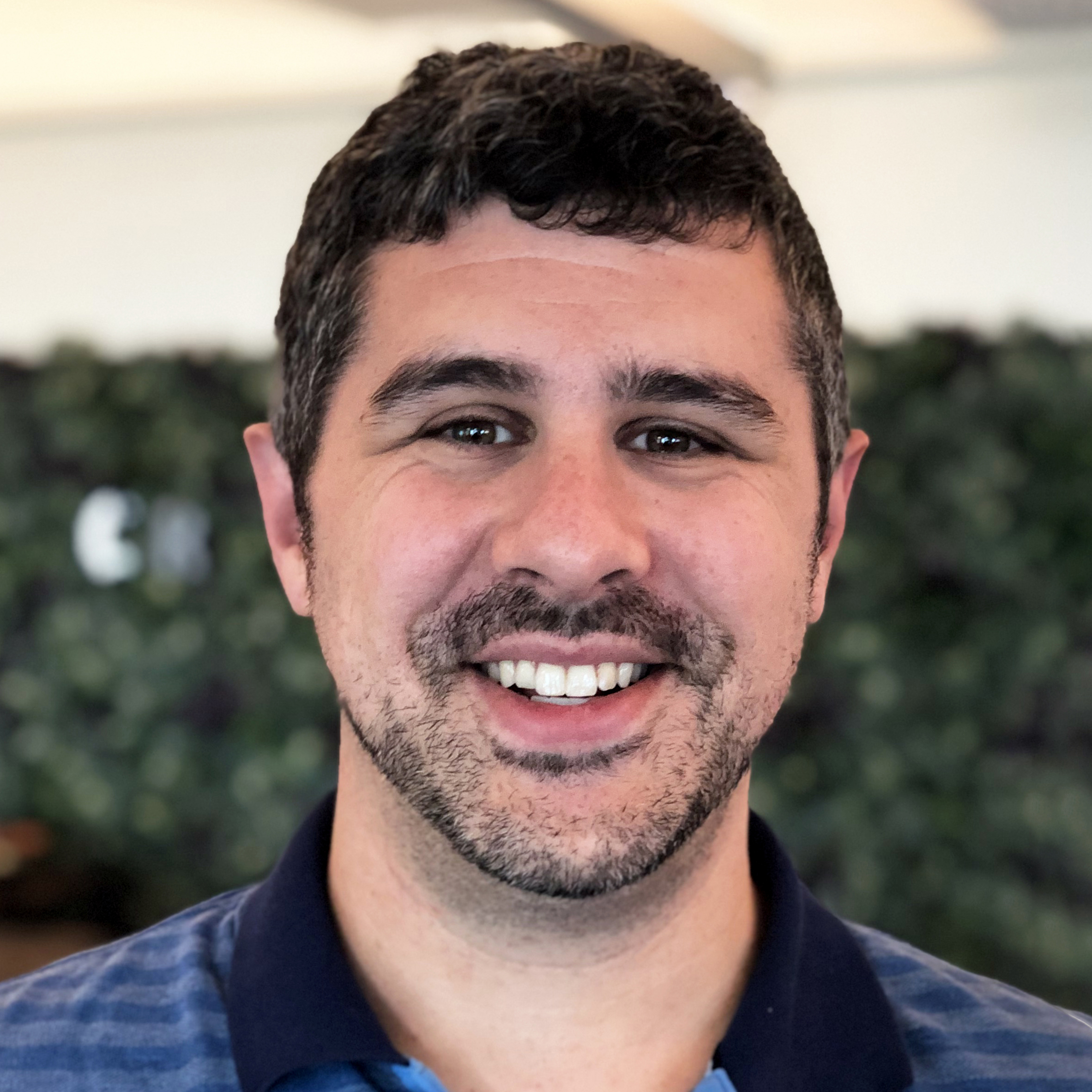 Daniel Fitzpatrick smiling in front of some ivy